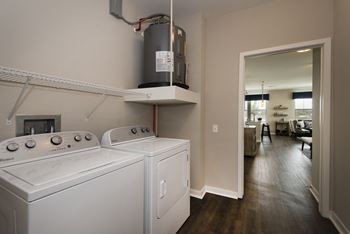 an empty laundry room with a washer and dryer in it and a kitchen  at Watermark on Twenty Mile, Parker, CO, 80134
